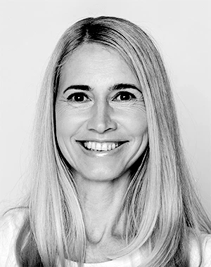 Leende kvinna med långt hår i svartvitt porträttfoto.